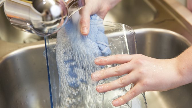 Washing the water reservoir from a Keurig coffee maker in a sink